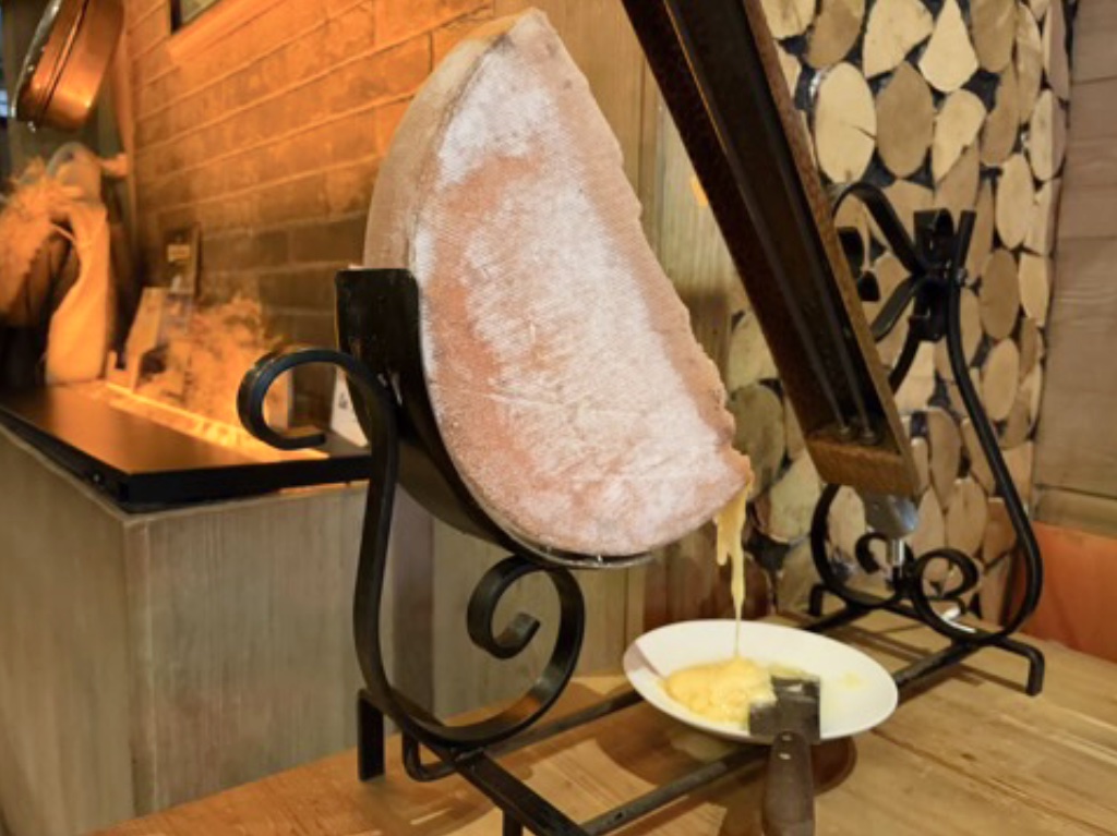 Raclette cheese on its melting apparatus.